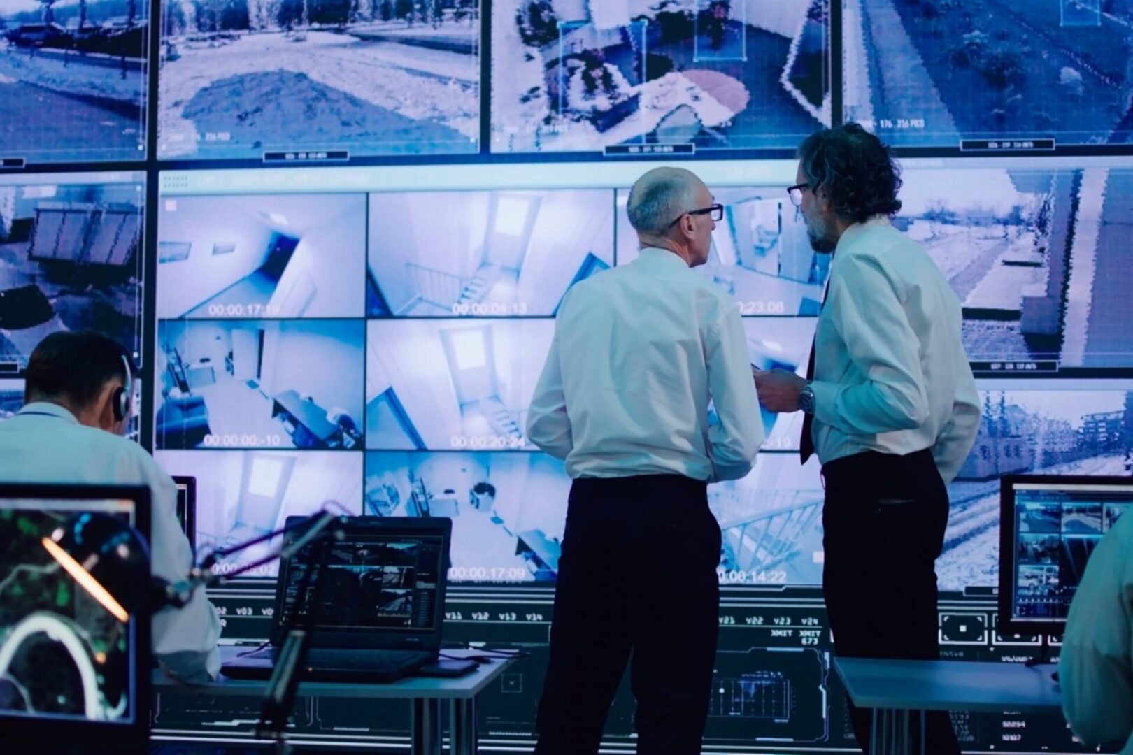 People analyzing surveillance footage in control room