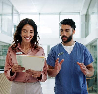 Nurses collaborating in hospital hallway