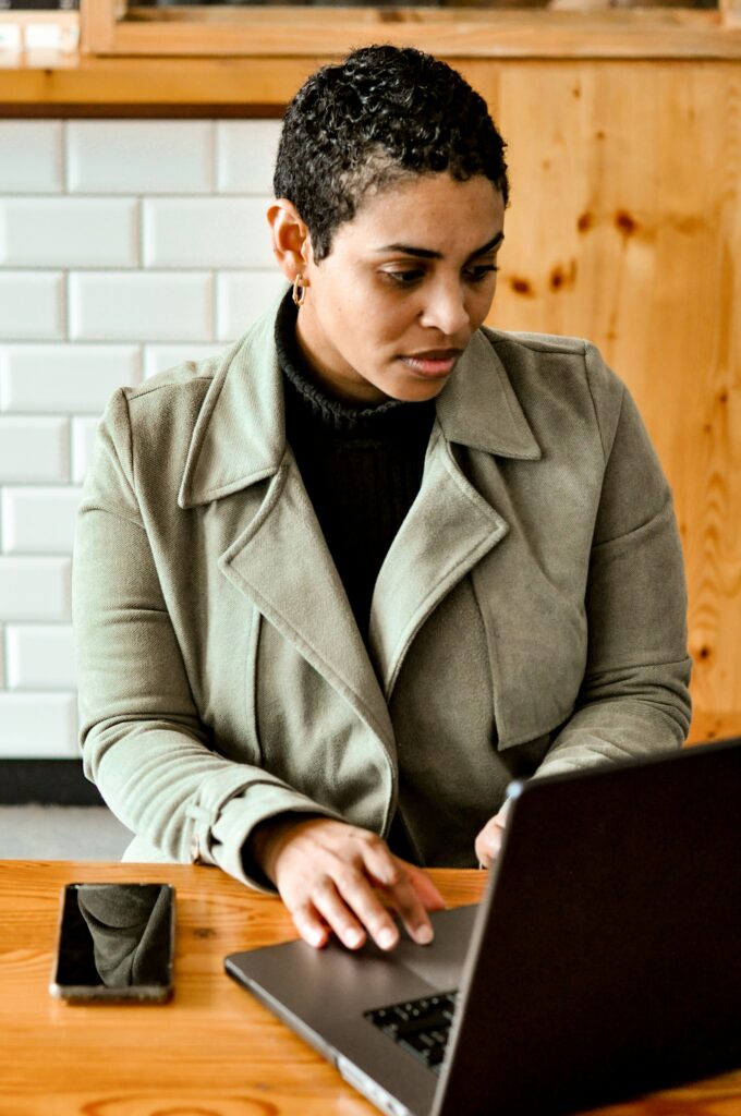 Person typing on laptop at wooden table